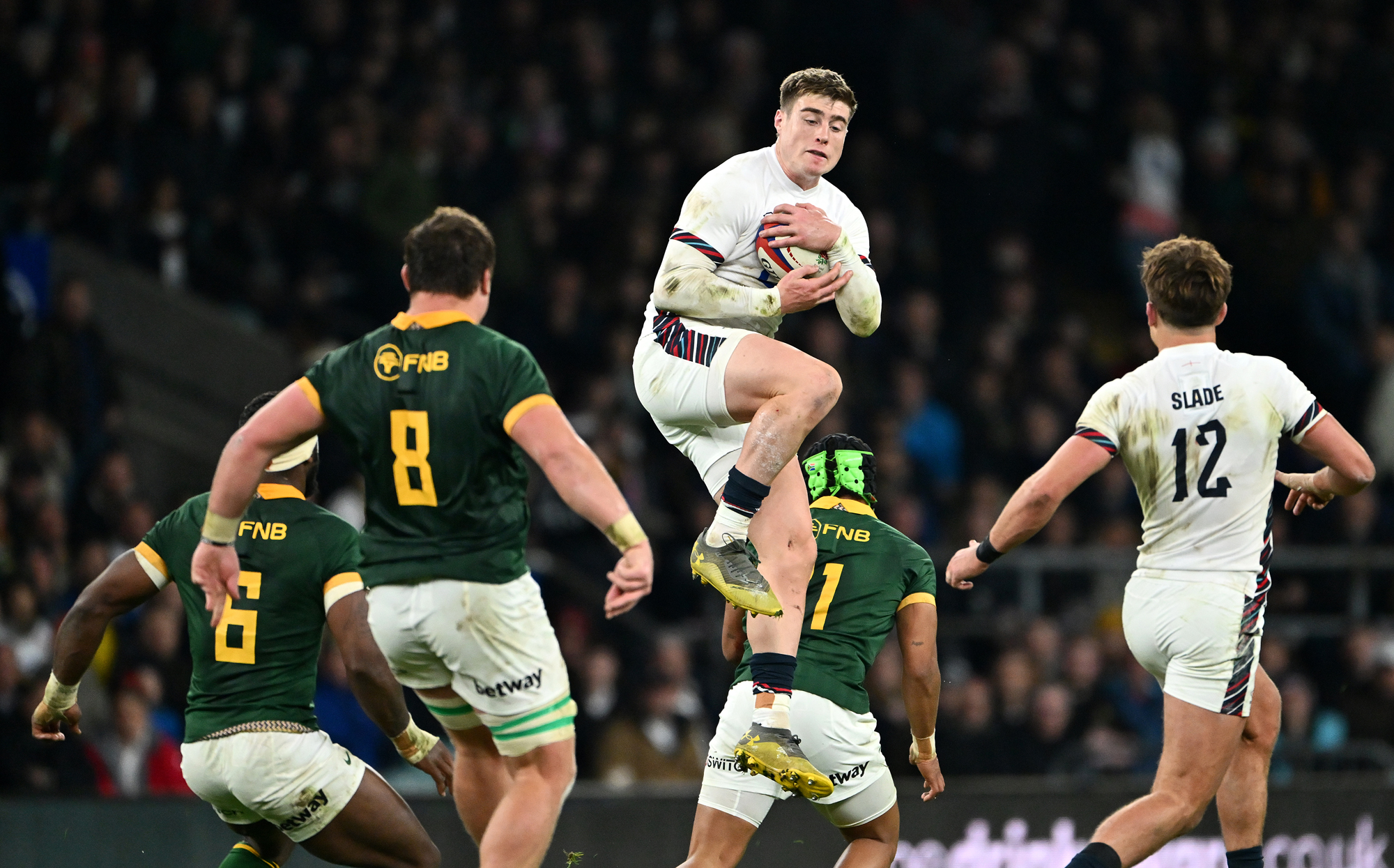 Tommy Freeman of England catches a high ball despite the attentions of Springboks players during the November 2024 Test match.